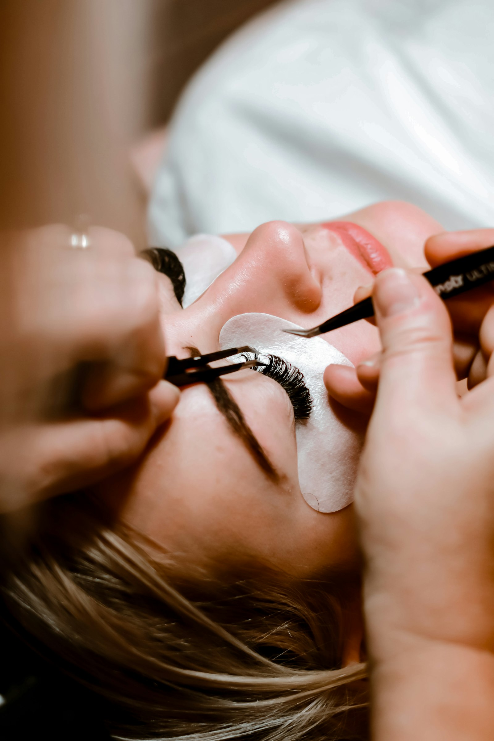 Lash artist applying extensions to a client